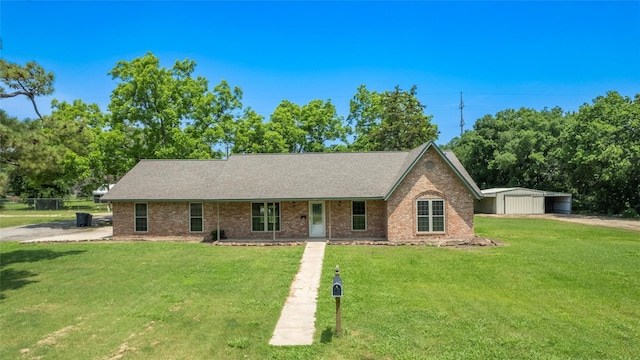 ranch-style house featuring a storage shed and a front lawn