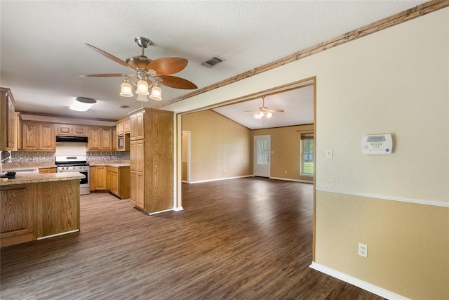 kitchen featuring tasteful backsplash, wood-type flooring, sink, stainless steel gas stove, and a textured ceiling