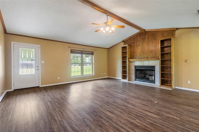 unfurnished living room with a textured ceiling, a tiled fireplace, plenty of natural light, and dark hardwood / wood-style flooring