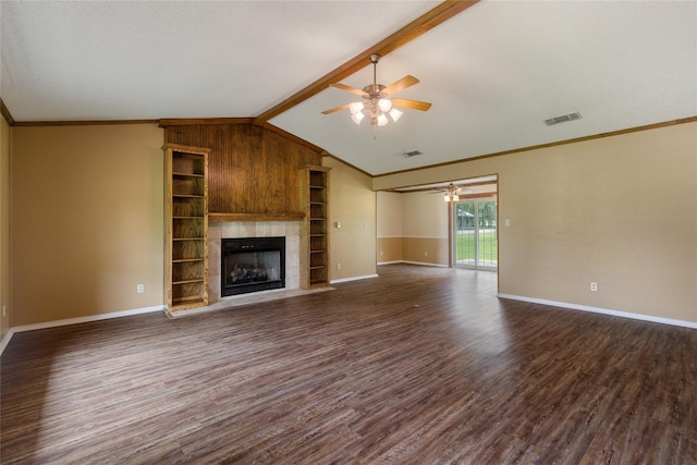 unfurnished living room with ceiling fan, dark wood-type flooring, a fireplace, ornamental molding, and vaulted ceiling with beams