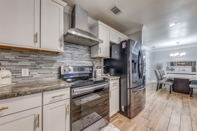 kitchen with visible vents, ornamental molding, wall chimney exhaust hood, a chandelier, and stainless steel appliances