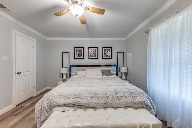 bedroom with ornamental molding, light wood-type flooring, multiple windows, and ceiling fan