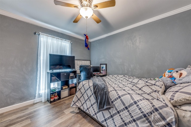bedroom featuring crown molding, ceiling fan, baseboards, and wood finished floors