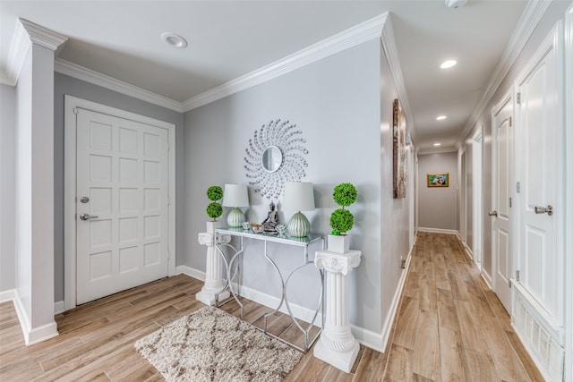 foyer with light hardwood / wood-style flooring and crown molding