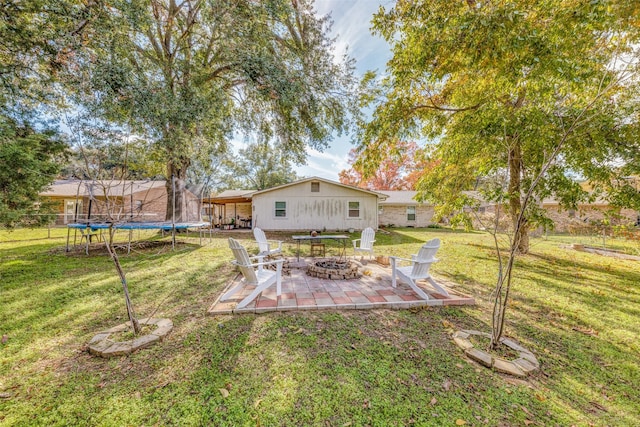 view of yard featuring a patio, a trampoline, and an outdoor fire pit