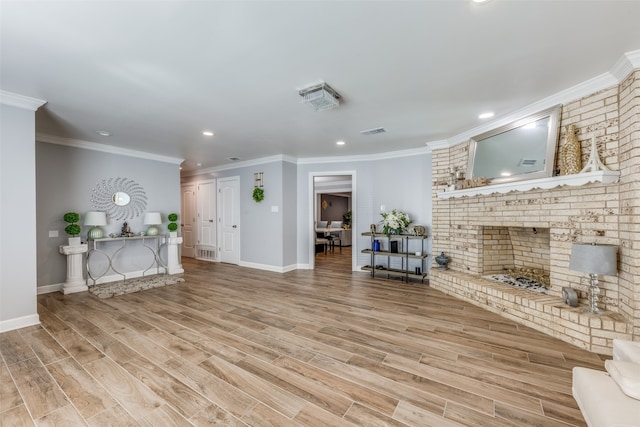 unfurnished living room featuring a brick fireplace, crown molding, and light hardwood / wood-style floors