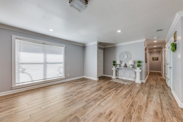 unfurnished living room featuring crown molding, visible vents, plenty of natural light, and light wood-style flooring