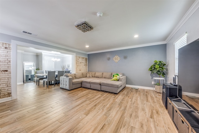 living room featuring light hardwood / wood-style floors, crown molding, and an inviting chandelier