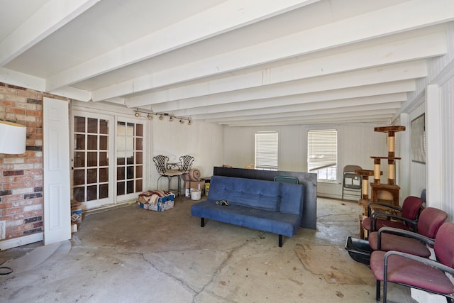 living room with beamed ceiling and brick wall