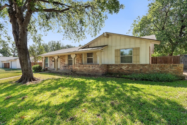 ranch-style house with a garage, a front lawn, and covered porch