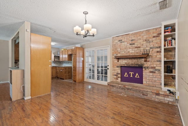 unfurnished living room with a chandelier, crown molding, dark hardwood / wood-style flooring, and a textured ceiling