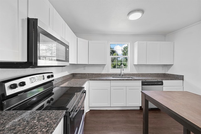 kitchen with appliances with stainless steel finishes, sink, white cabinetry, dark stone countertops, and dark wood-type flooring