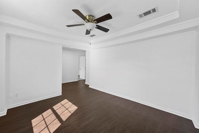 spare room featuring ceiling fan, ornamental molding, a tray ceiling, and dark hardwood / wood-style floors