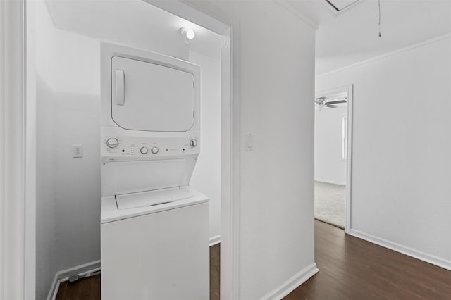 laundry room with stacked washer and dryer, dark wood-type flooring, and ceiling fan