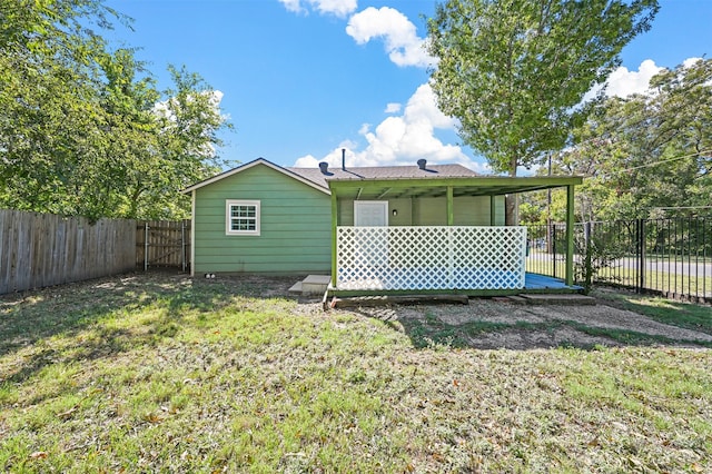 rear view of house featuring a deck and a lawn