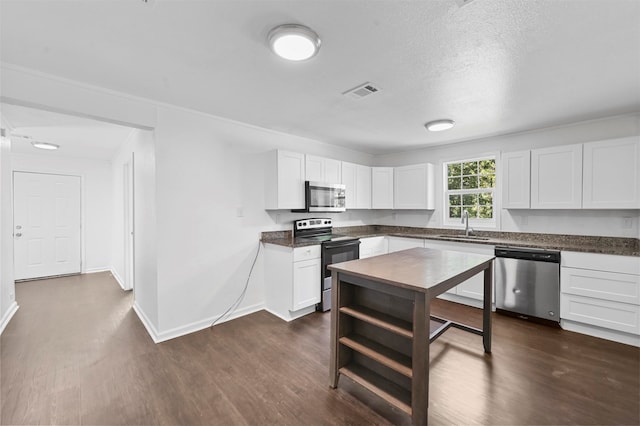 kitchen with white cabinetry, stainless steel appliances, dark hardwood / wood-style flooring, and sink