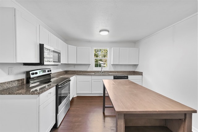 kitchen with appliances with stainless steel finishes, white cabinetry, a textured ceiling, dark wood-type flooring, and sink