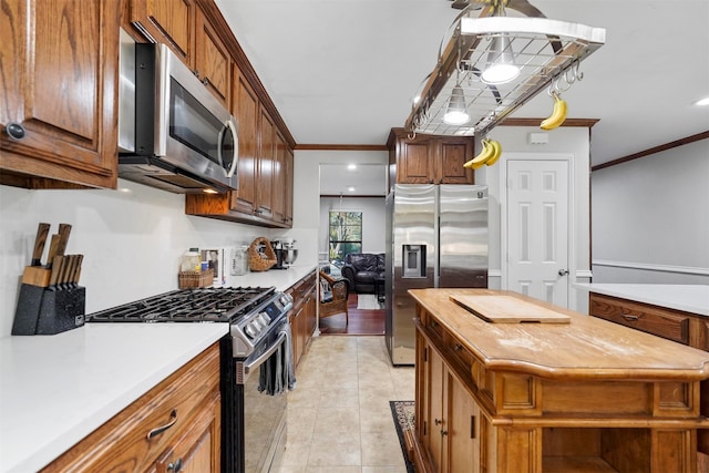 kitchen with wood counters, light tile patterned flooring, ornamental molding, and appliances with stainless steel finishes