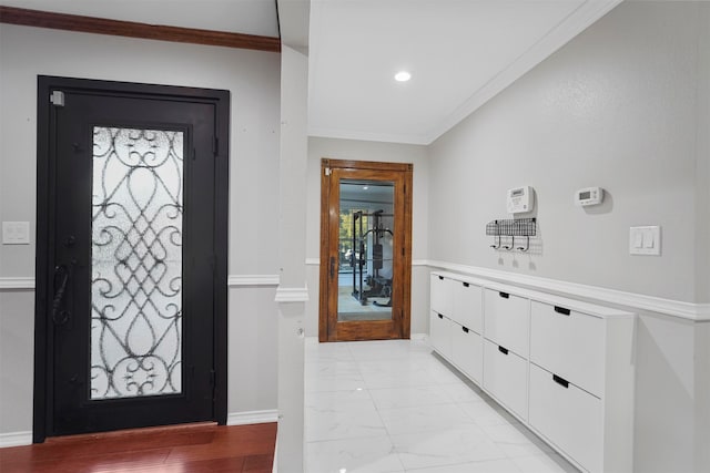 foyer entrance featuring light hardwood / wood-style floors and crown molding