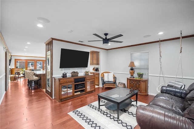 living room with hardwood / wood-style flooring, ceiling fan, and ornamental molding