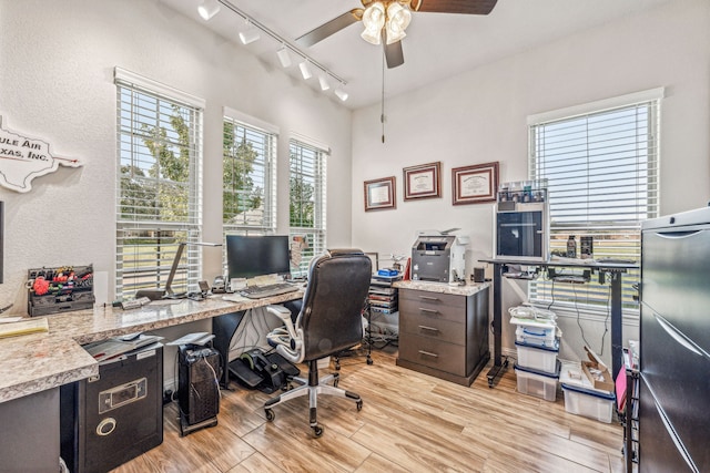 office featuring ceiling fan, light wood-type flooring, and track lighting