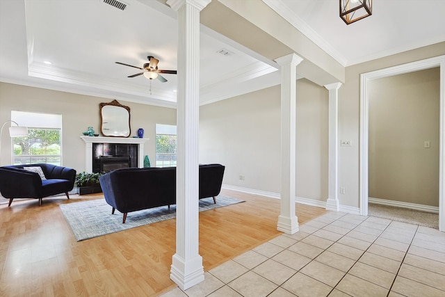 living room with decorative columns, a fireplace, and light hardwood / wood-style flooring