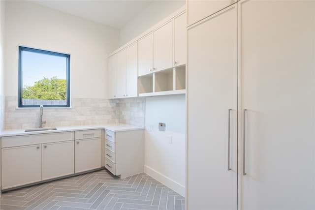 washroom with cabinets, hookup for an electric dryer, and sink