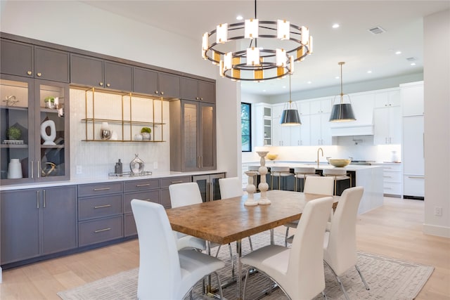 dining space with an inviting chandelier and light hardwood / wood-style flooring