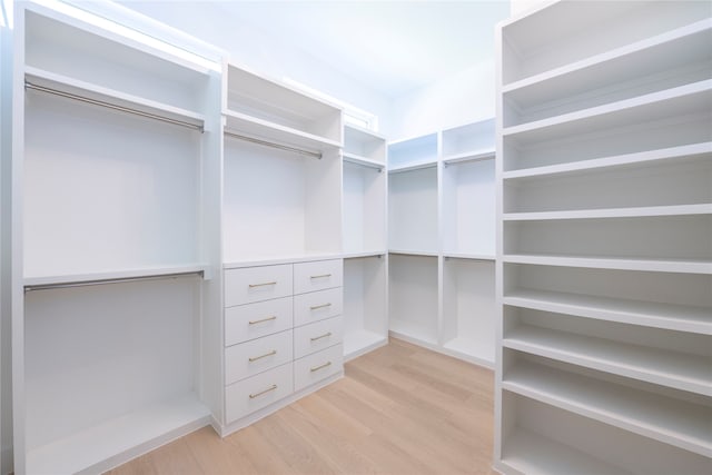 walk in closet with light hardwood / wood-style floors