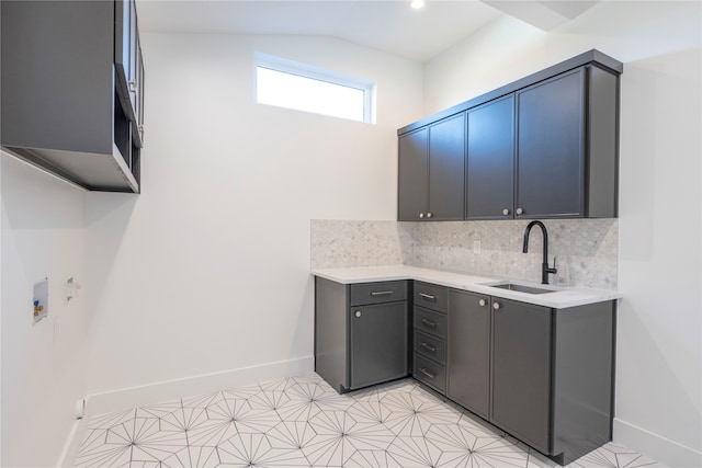 kitchen featuring vaulted ceiling, sink, and backsplash