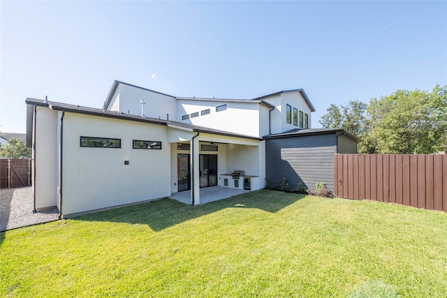 back of house with a patio and a yard