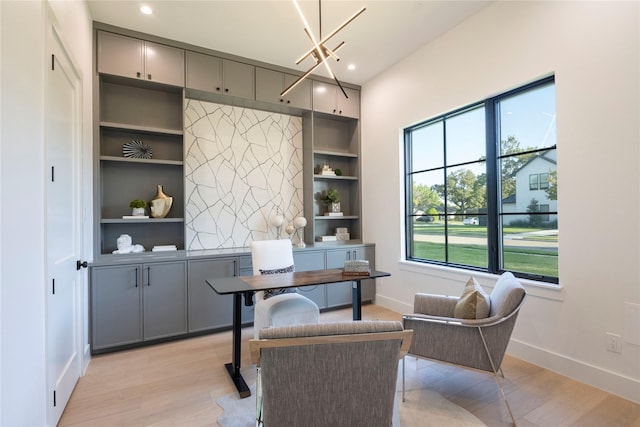 office with light hardwood / wood-style flooring, built in features, and a chandelier