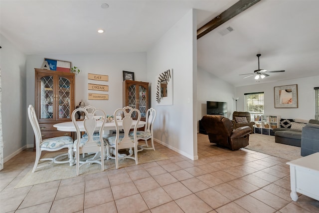 dining space featuring ceiling fan, light tile patterned flooring, and vaulted ceiling with beams