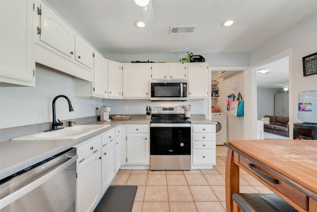 kitchen featuring ceiling fan, appliances with stainless steel finishes, sink, washer / clothes dryer, and white cabinets