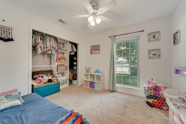 carpeted bedroom featuring ceiling fan, multiple windows, and a closet