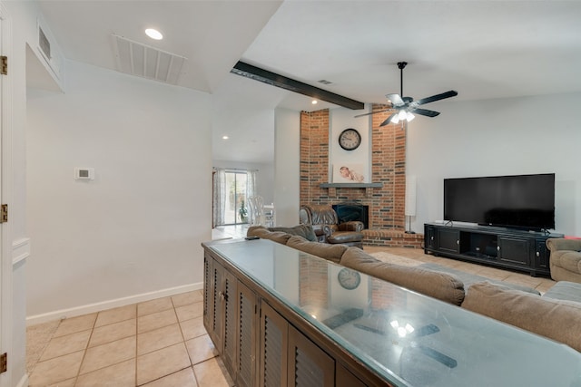 living room with a fireplace, beam ceiling, light tile patterned floors, and ceiling fan