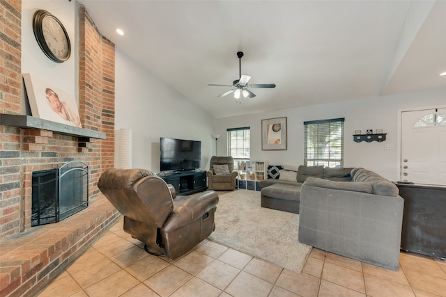 tiled living room with a brick fireplace, ceiling fan, and vaulted ceiling