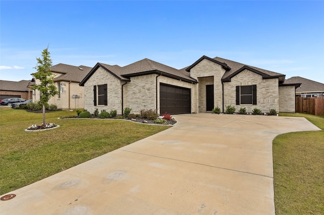 french country style house with a front yard and a garage