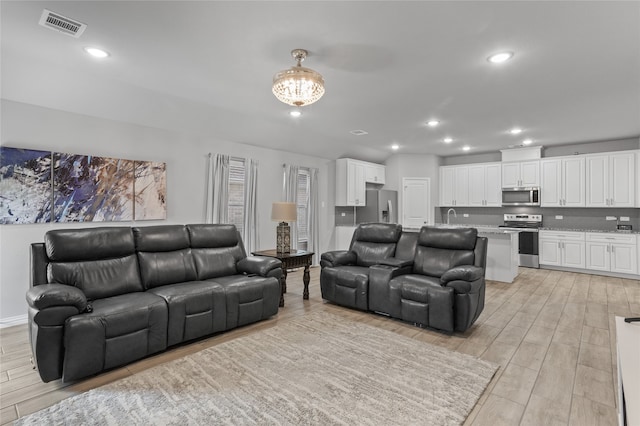 living room featuring light hardwood / wood-style floors and sink