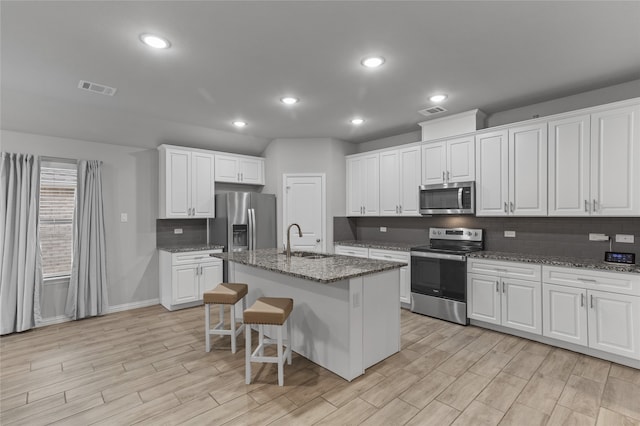 kitchen with white cabinetry, sink, an island with sink, and appliances with stainless steel finishes