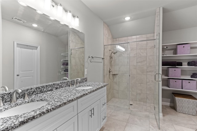 bathroom featuring tile patterned flooring, vanity, and walk in shower