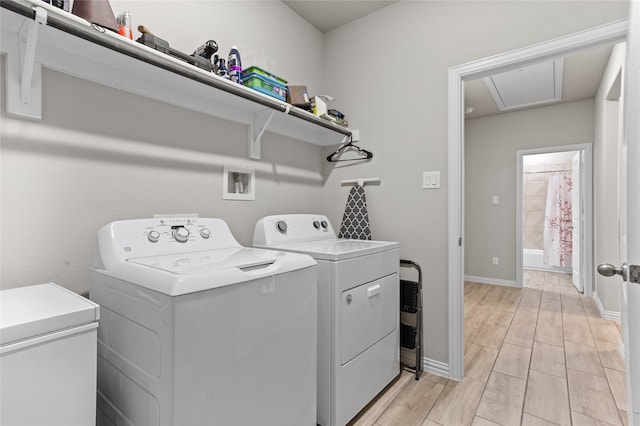 washroom featuring light wood-type flooring and washing machine and clothes dryer