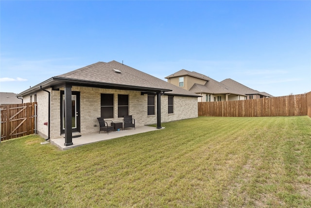 back of property with a lawn and a patio