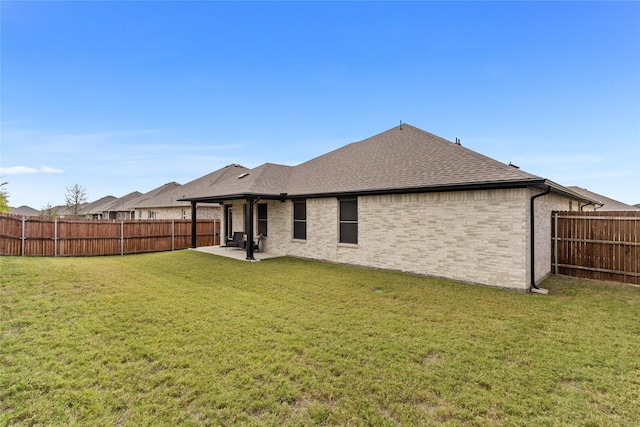 rear view of house featuring a lawn and a patio