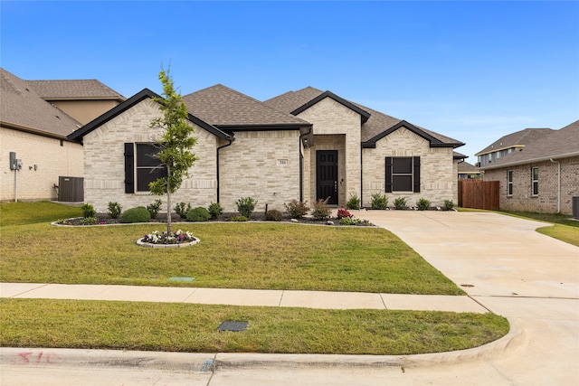 french country inspired facade with a front lawn and central AC unit