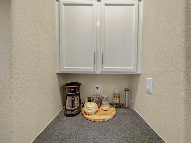 bar with white cabinets and carpet