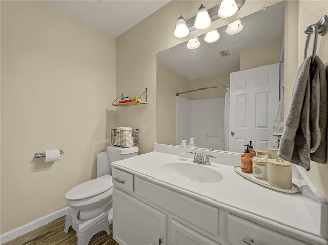 bathroom featuring vanity, a shower, hardwood / wood-style floors, and toilet