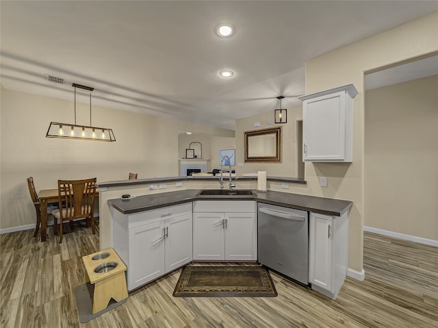 kitchen with sink, kitchen peninsula, pendant lighting, white cabinetry, and dishwasher