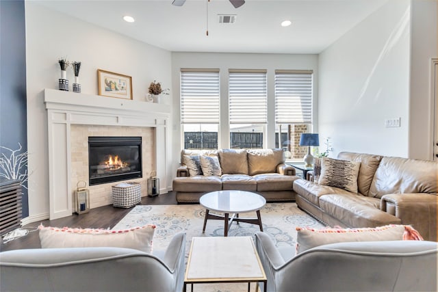 living room featuring dark hardwood / wood-style floors, ceiling fan, and a fireplace