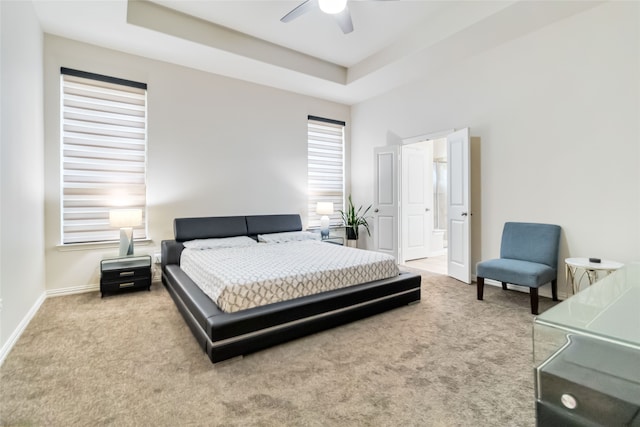 bedroom with carpet flooring, ceiling fan, and a raised ceiling